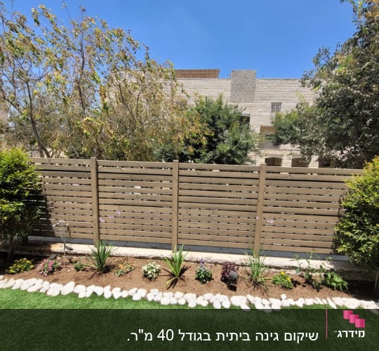 ערוגת פרחים עם אבנים ודשא ירוק